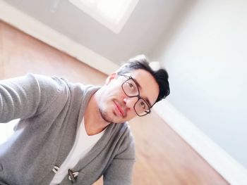 Portrait of young man wearing eyeglasses at home