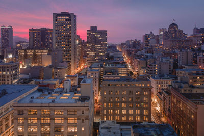 High angle view of illuminated buildings in city at dusk