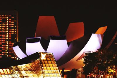 Low angle view of illuminated building against sky at night