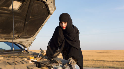 Islamic woman driver owner of car at open door. traditional islamic clothing