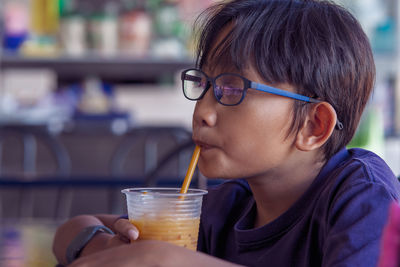 Close-up of boy drinking juice at restaurant