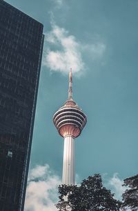 Low angle view of communications tower and buildings against sky