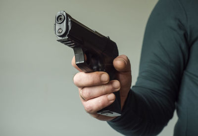 Close-up of man holding hands over white background