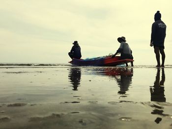 People on boat in sea against sky