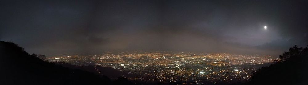 Aerial view of illuminated cityscape against sky at night