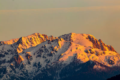 Scenic view of snowcapped mountains against sky during sunset