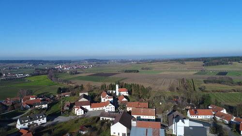 Aerial view of houses against clear blue sky