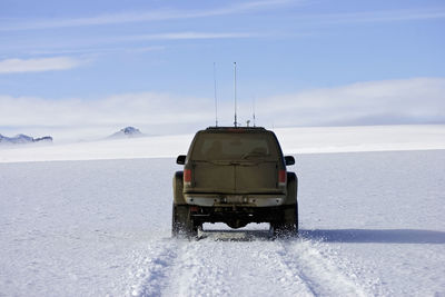 Customised suv ploughing through snowy landscape on icelandic glacier