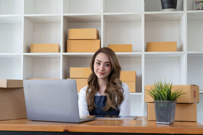 Portrait of young woman using laptop at table