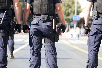 Midsection of people standing on street in city