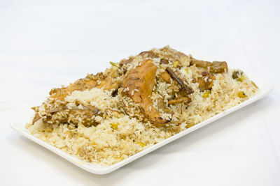 Close-up of food in plate against white background