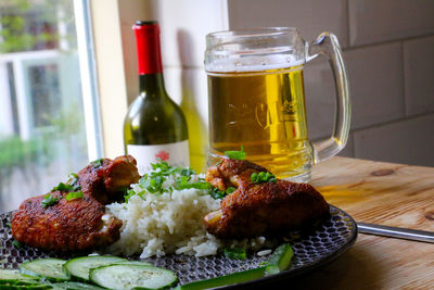 Close-up of meat in plate and beer on table