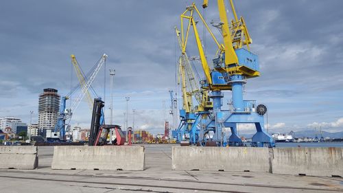 Cranes at construction site against sky