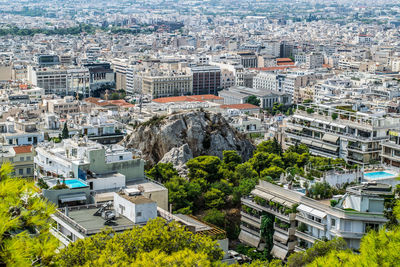 High angle view of historic athens, greece. trees and hills are mixed within the many buildings.
