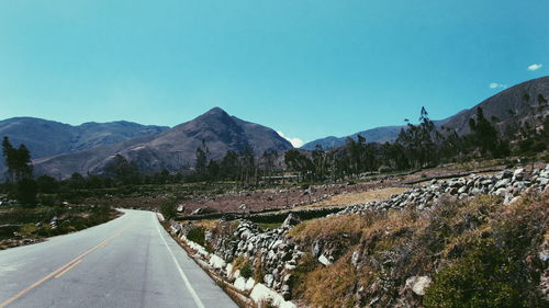 Empty road with mountains in background