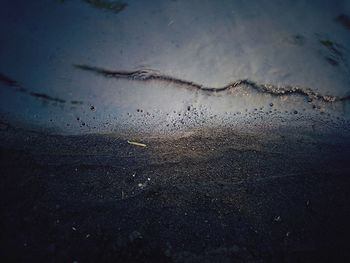 Scenic view of wet beach against sky