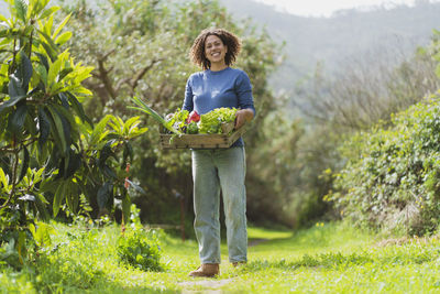 Portrait of smiling woman standing on plants