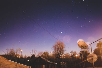 Low angle view of illuminated trees against sky at night