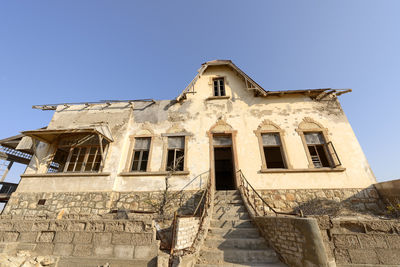 Low angle view of old building against clear blue sky