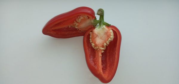 High angle view of red chili peppers against white background