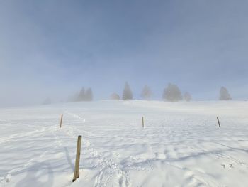 Scenic view of snow covered field against sky