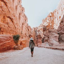 Rear view of woman walking on rock formation