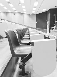 Empty chairs and tables in illuminated room