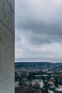 High angle view of city buildings against cloudy sky