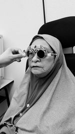 Cropped hand of optician testing woman eyesight