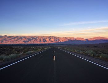 Empty road leading towards mountains