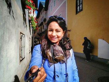 Portrait of smiling young woman on street in city