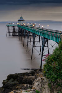 Pier on sea against cloudy sky