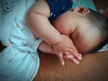 Close-up of baby lying on bed