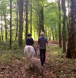 Rear view of couple walking in forest