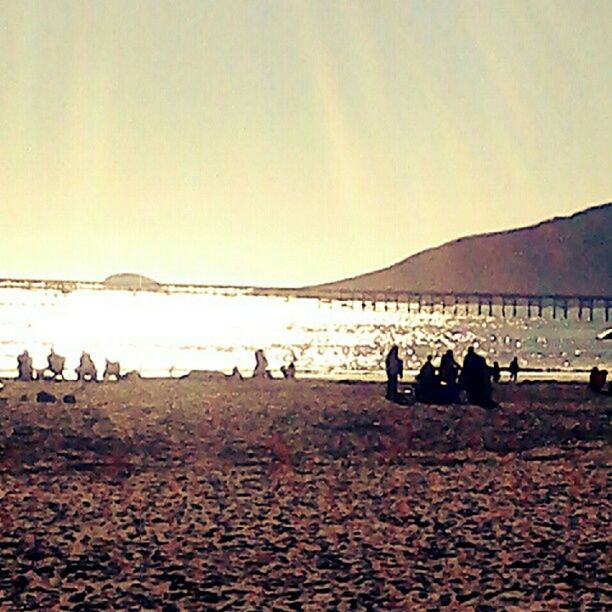 beach, large group of people, sand, copy space, clear sky, tranquil scene, scenics, tranquility, sunset, sky, beauty in nature, landscape, nature, mountain, leisure activity, men, sea, water, lifestyles