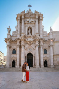 People standing outside temple against building