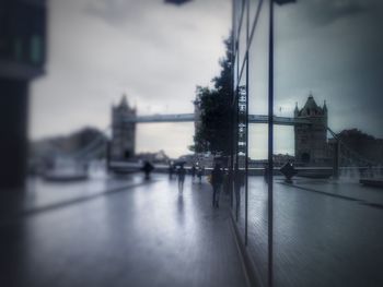 Bridge over river in city against sky