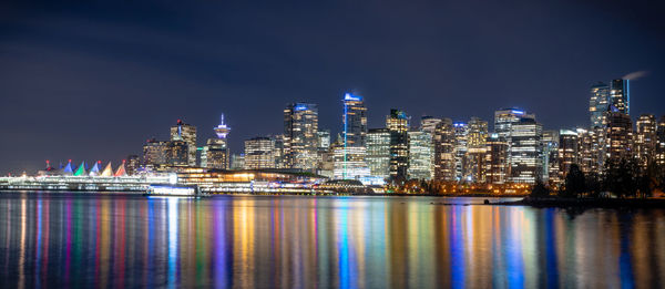 Illuminated buildings against sky at night