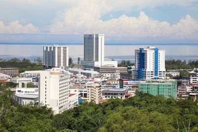 Cityscape by sea against sky