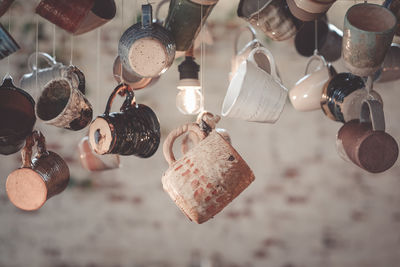 Close-up of ceramic cups hanging in store