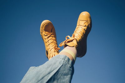 Low section of man against blue sky