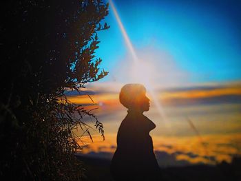 Silhouette woman standing against sky during sunset