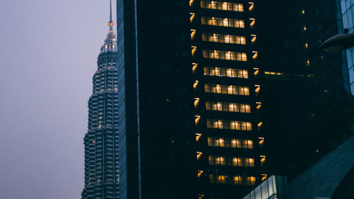Low angle view of illuminated buildings against sky at dusk