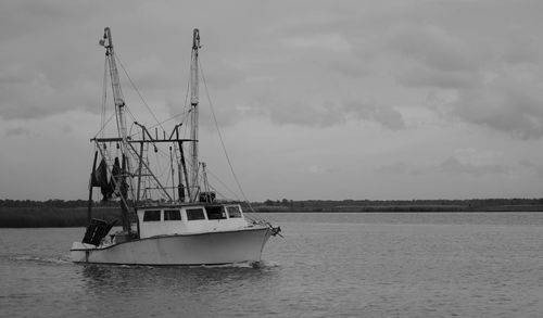 Black and white photo of a fishing boat heading out of apalachicola bay in apalachicola, florida, us