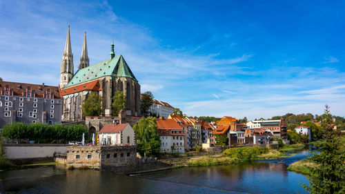 River amidst buildings in city against sky