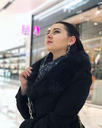 Side view of young woman standing indoors