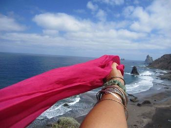 Low section of woman on beach against sky