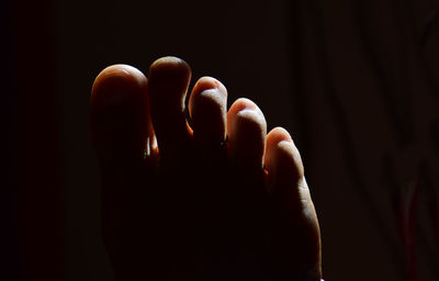 Close-up of human foot against black background