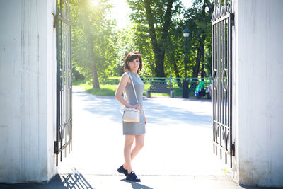 Full length of woman standing against wall