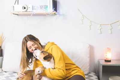 Woman with dog on sofa at home